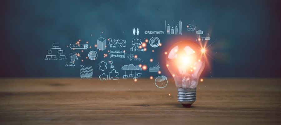 A graphic of a lightbulb on a table with sketches of creative ideas surrounding it.