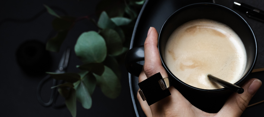An image of a hand holding a mug of milky tea, which is a drink that can help you sleep.