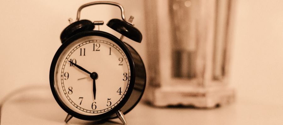 A sepia tinted image of an alarm clock that says it is 5:10.