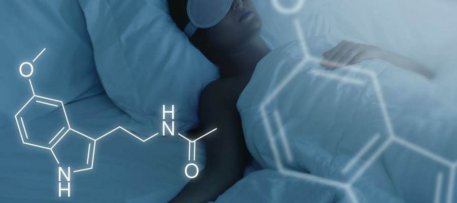 A woman is asleep in bed wearing a sleep mask over her eyes. There is the chemical formula for melatonin in the corner of the image.